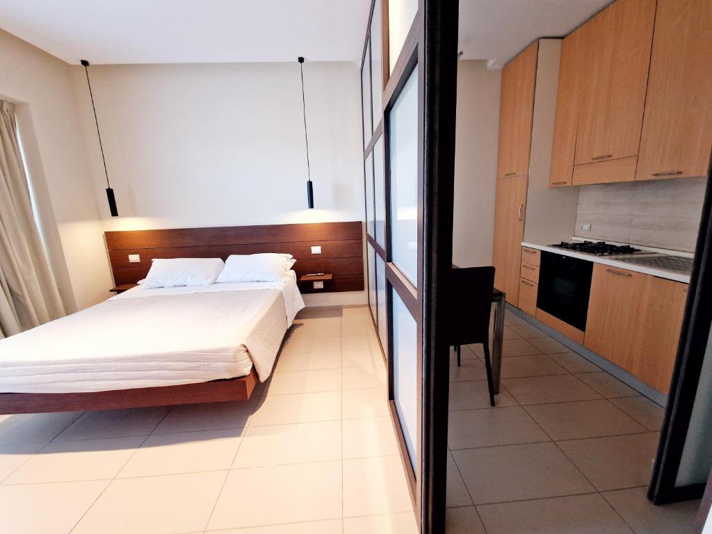 une petite chambre avec un lit et une cuisine dans l'établissement Martur Resort, à Termoli