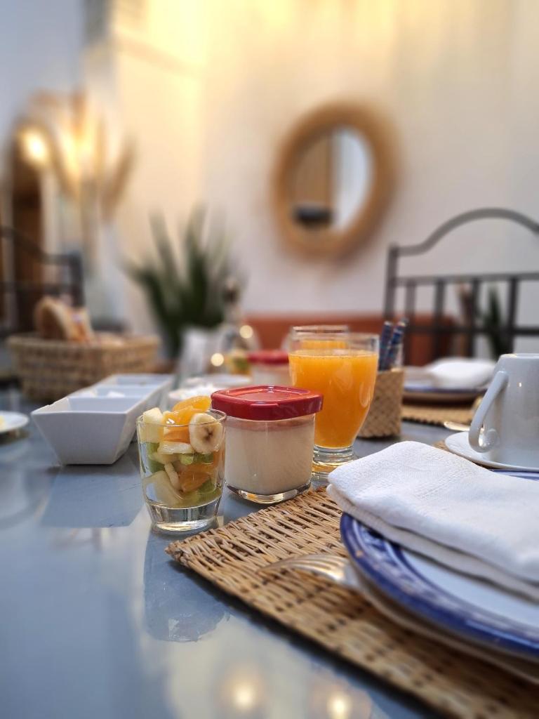 une table recouverte de bols de nourriture et de jus d'orange dans l'établissement Dar El Bali, à Fès
