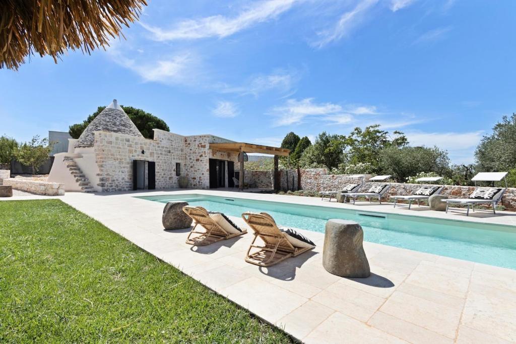 une villa avec piscine et chaises longues dans l'établissement Trullo Lamatroccola, à Ceglie Messapica