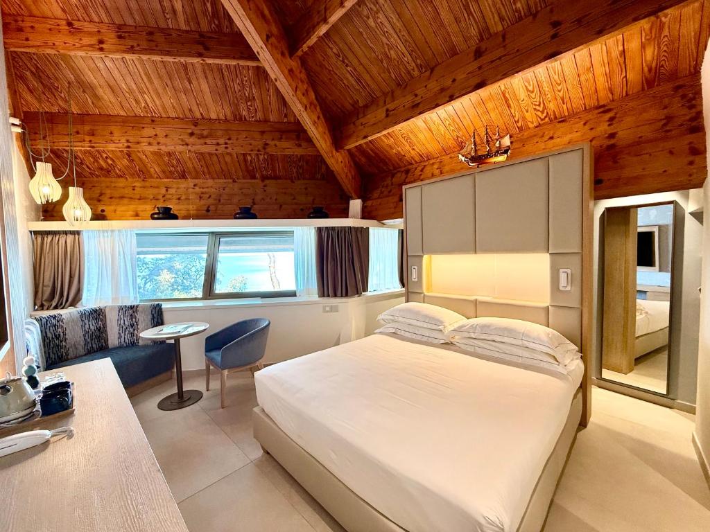 - une chambre avec un lit blanc au plafond en bois dans l'établissement La Bussola Beach Hotel, à Punta Ala 86 autres photos