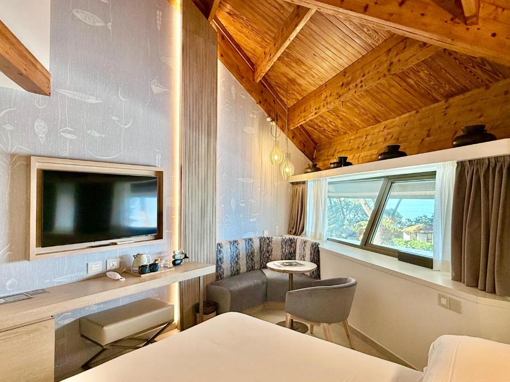 une chambre avec un lit, une télévision et une fenêtre dans l'établissement La Bussola Beach Hotel, à Punta Ala