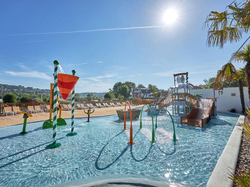 une piscine avec un toboggan et une aire de jeux dans l'établissement LJ Cosy Lodge - Mobilhome, à Houlgate