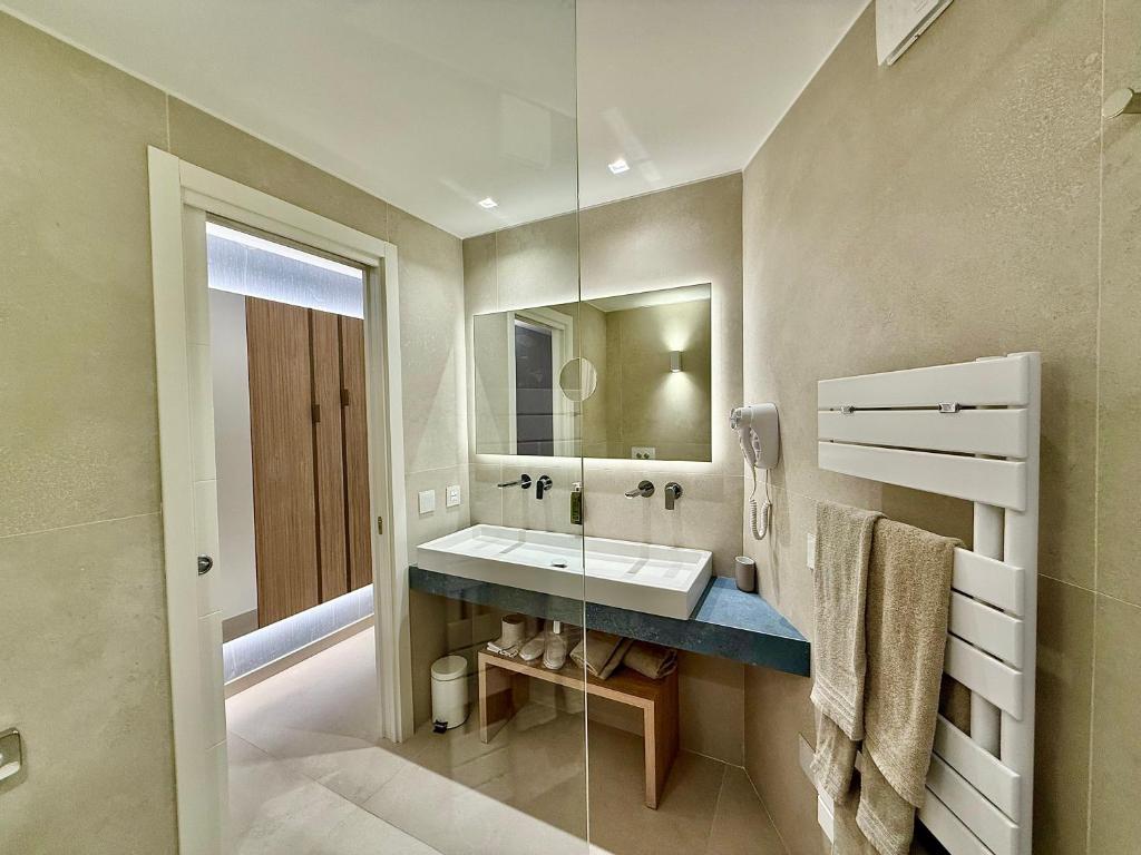 une salle de bain avec un lavabo et un miroir dans l'établissement La Bussola Beach Hotel, à Punta Ala