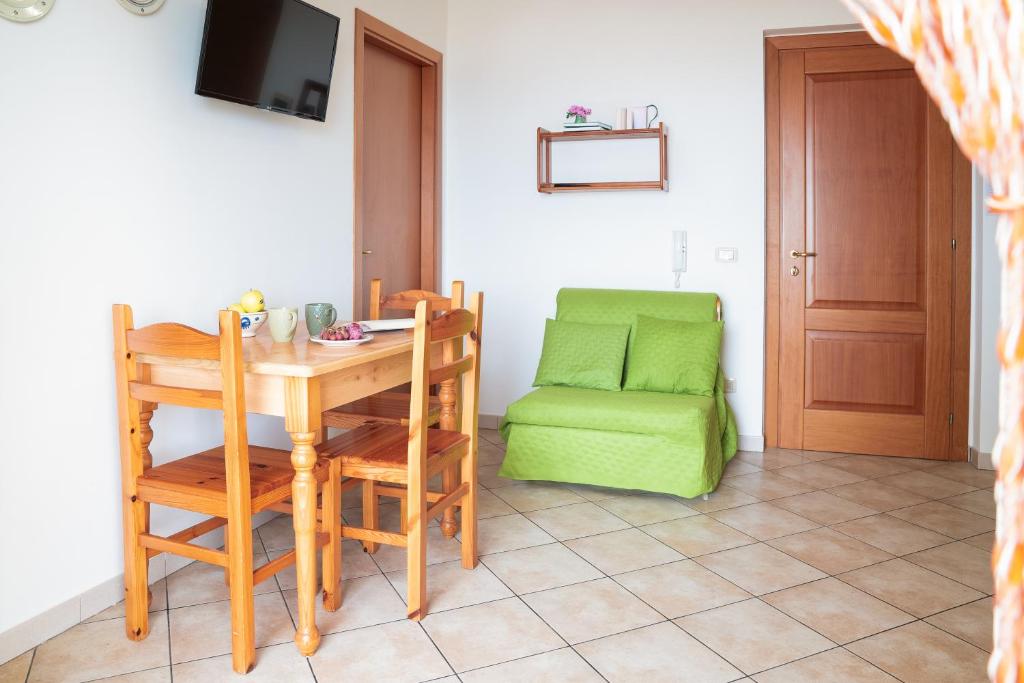 une salle à manger avec une table et une chaise verte dans l'établissement Residence Chiesiola, à Vieste