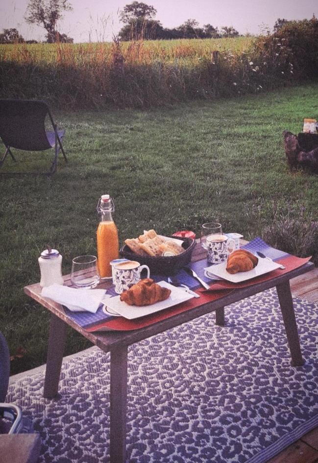 - une table de pique-nique avec de la nourriture et des boissons dans l'établissement Caravane Seventies avec jacuzzi, à Lapalisse