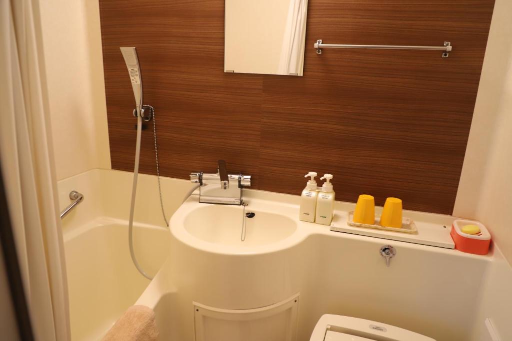 une salle de bain avec un lavabo, des toilettes et une douche dans l'établissement Hotel Mimatsu, à Nara