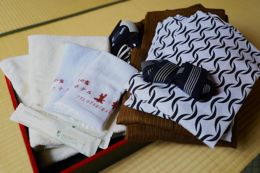 une boîte remplie de serviettes et de vêtements sur une table dans l'établissement Hotel Mimatsu, à Nara