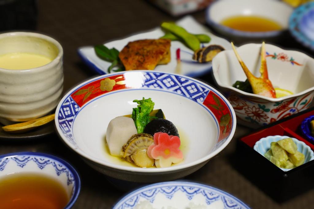 - une table avec des assiettes de nourriture et des bols de soupe dans l'établissement Hotel Mimatsu, à Nara