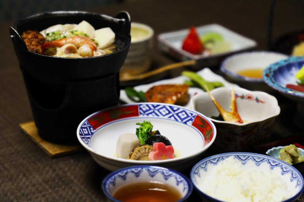 une table avec des bols de nourriture et un pot de riz dans l'établissement Hotel Mimatsu, à Nara