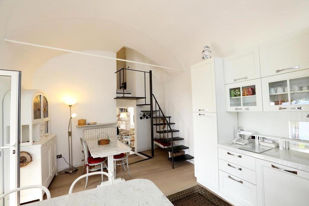 une cuisine avec des armoires blanches et une table avec des chaises dans l'établissement Villa Eos, à Santa Margherita Ligure