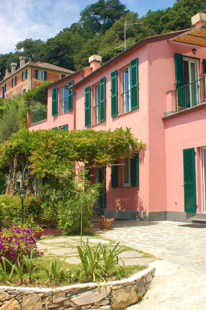 une maison rose avec des fenêtres à volets verts et des fleurs dans l'établissement Villa Eos, à Santa Margherita Ligure