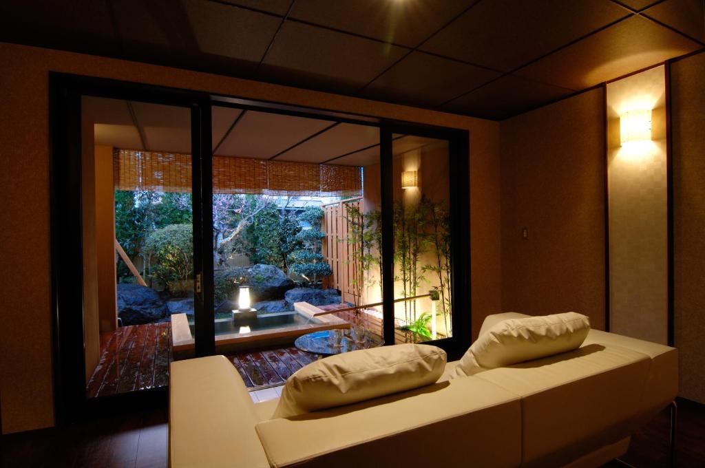 un salon avec un canapé et une grande fenêtre dans l'établissement Kouyurou Ikawa, à Izunokuni