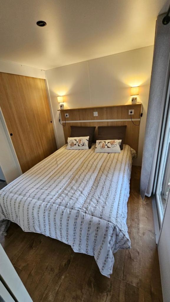 une chambre avec un lit avec deux oreillers dessus dans l'établissement Les bords du Rhône, à Condrieu