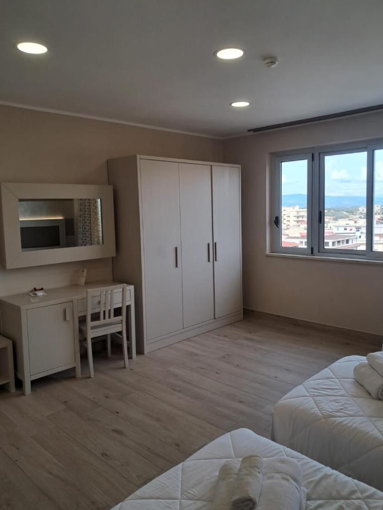 une chambre avec un lit, un bureau et une fenêtre dans l'établissement Hotel Palace Gioia Tauro, à Gioia Tauro