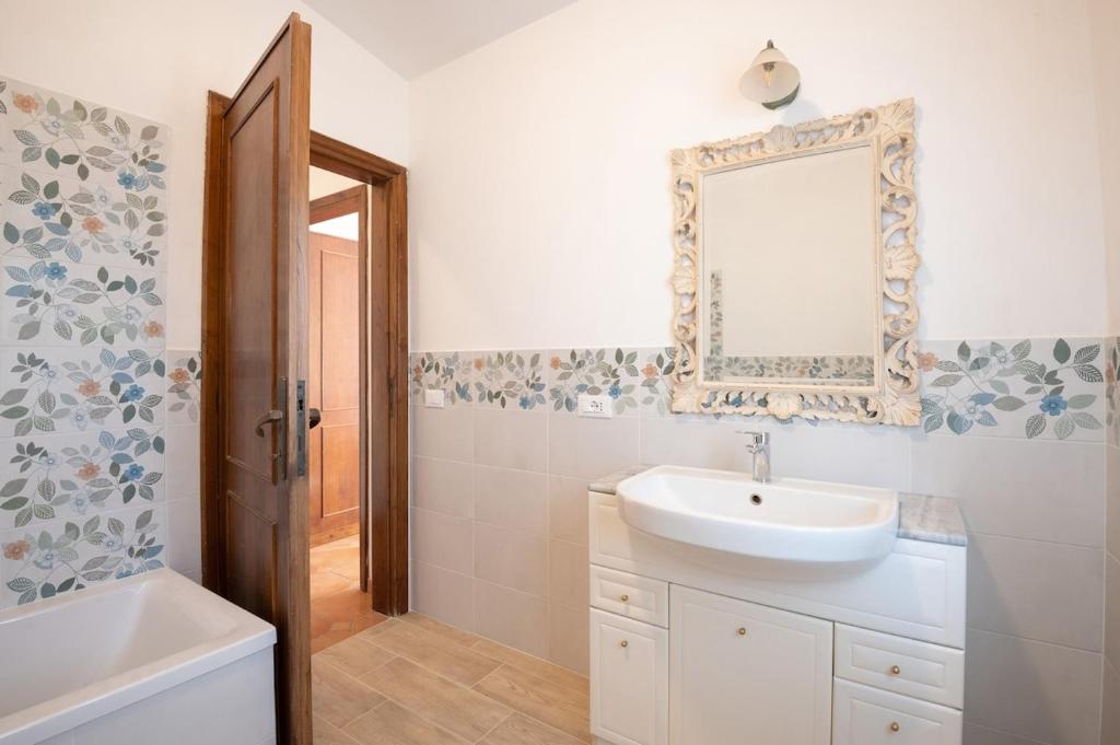 une salle de bain avec un lavabo et un miroir au mur dans l'établissement Villa immersed in green Isola dei Cavalli, à Quadroni 62 autres photos