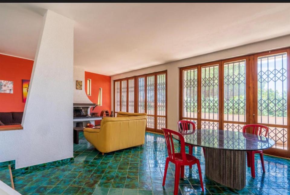 un salon avec une table et un canapé jaune dans l'établissement B&S Beach villa con piscina, à Fontane Bianche