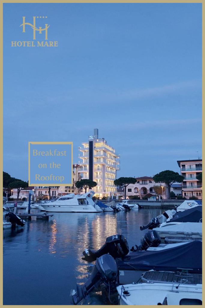 un groupe de bateaux amarrés dans un port avec un panneau dans l'établissement Hotel Mare, à Lignano Sabbiadoro