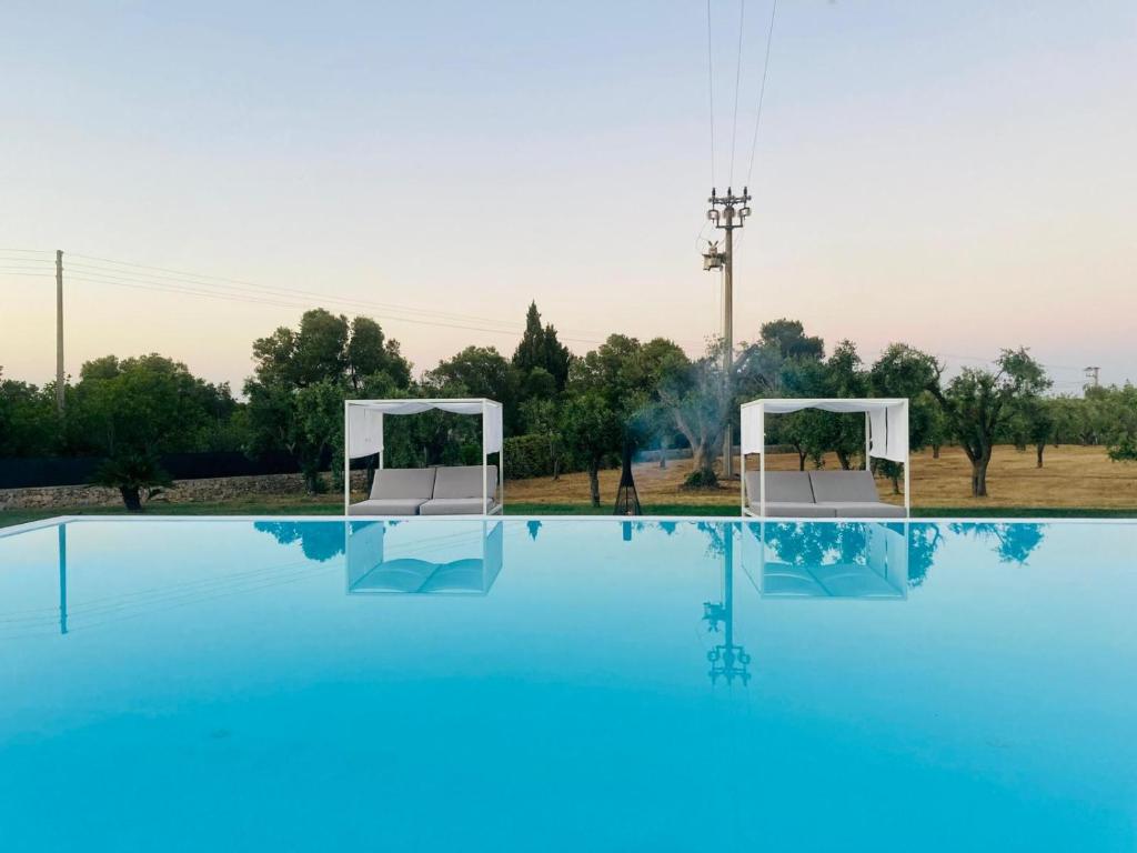 - une vue sur la piscine dotée de 2 chaises blanches dans l'établissement Villa Clive Relax & Sun, à Ostuni