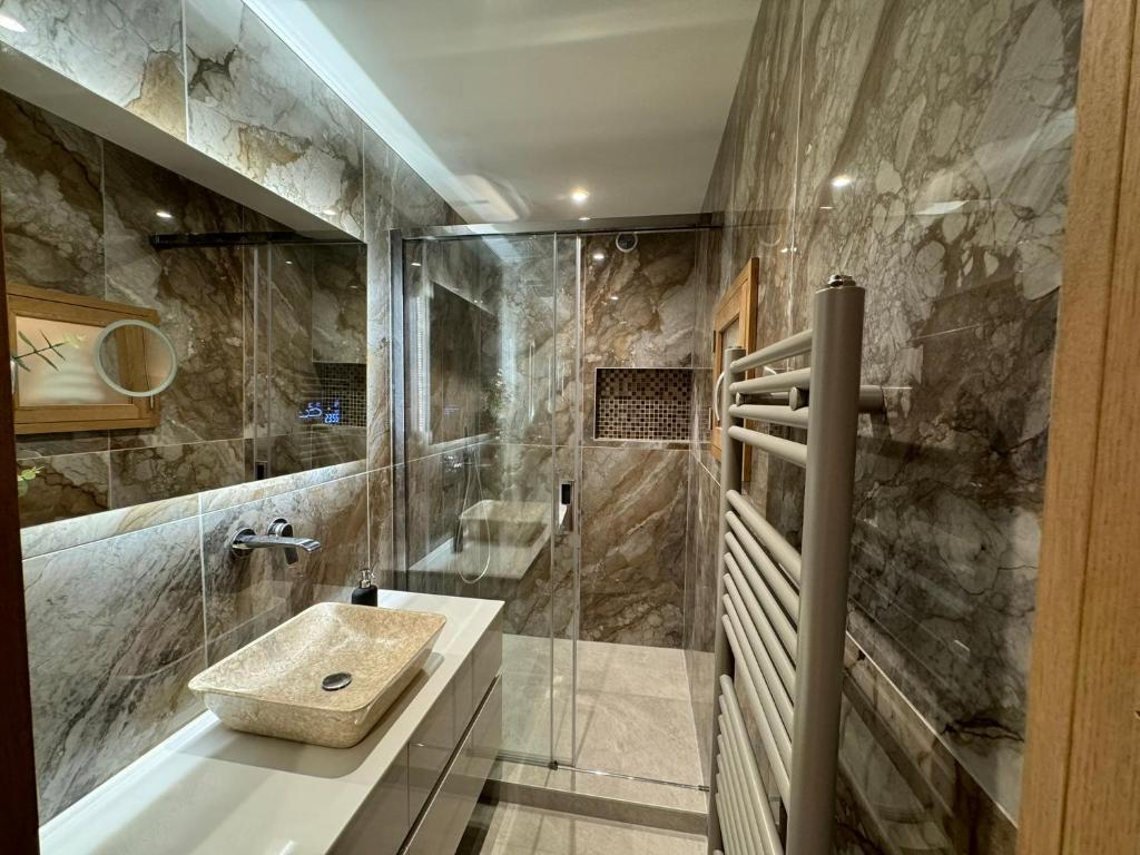 une salle de bain avec un lavabo et une douche dans l'établissement Chalet Evidence, à Montvalezan