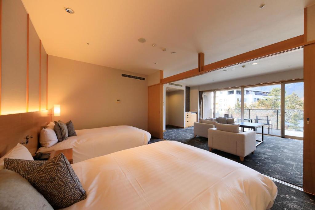 une chambre d'hôtel avec deux lits et un salon dans l'établissement Hakone Hisui, à Hakone