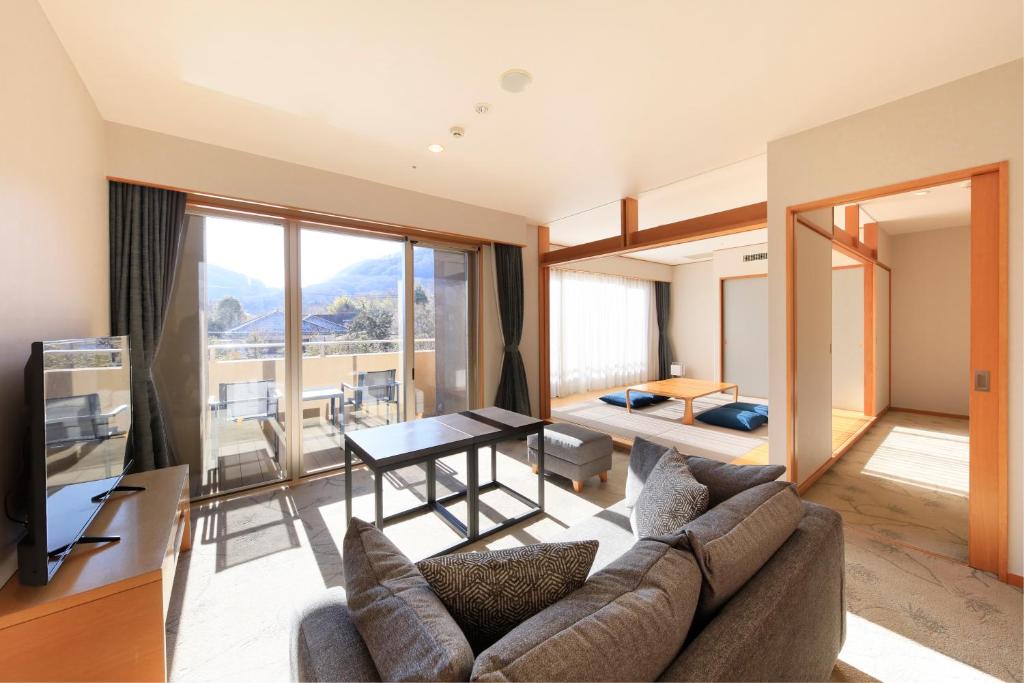 un salon avec un canapé et une table avec vue dans l'établissement Hakone Hisui, à Hakone