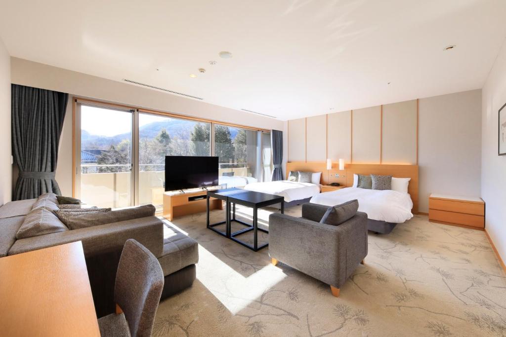 une chambre d'hôtel avec un lit et un salon dans l'établissement Hakone Hisui, à Hakone