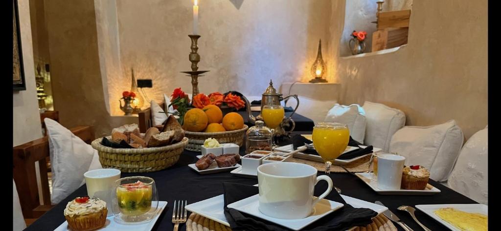 une table avec des aliments et des boissons pour le petit-déjeuner dans l'établissement Riad MALAÏKA, à Essaouira