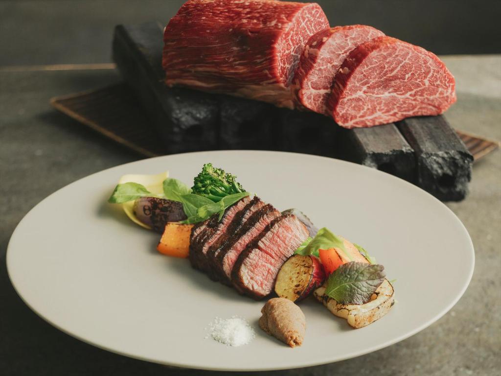 une plaque blanche contenant de la viande et des légumes dans l'établissement SOKI ATAMI, à Atami