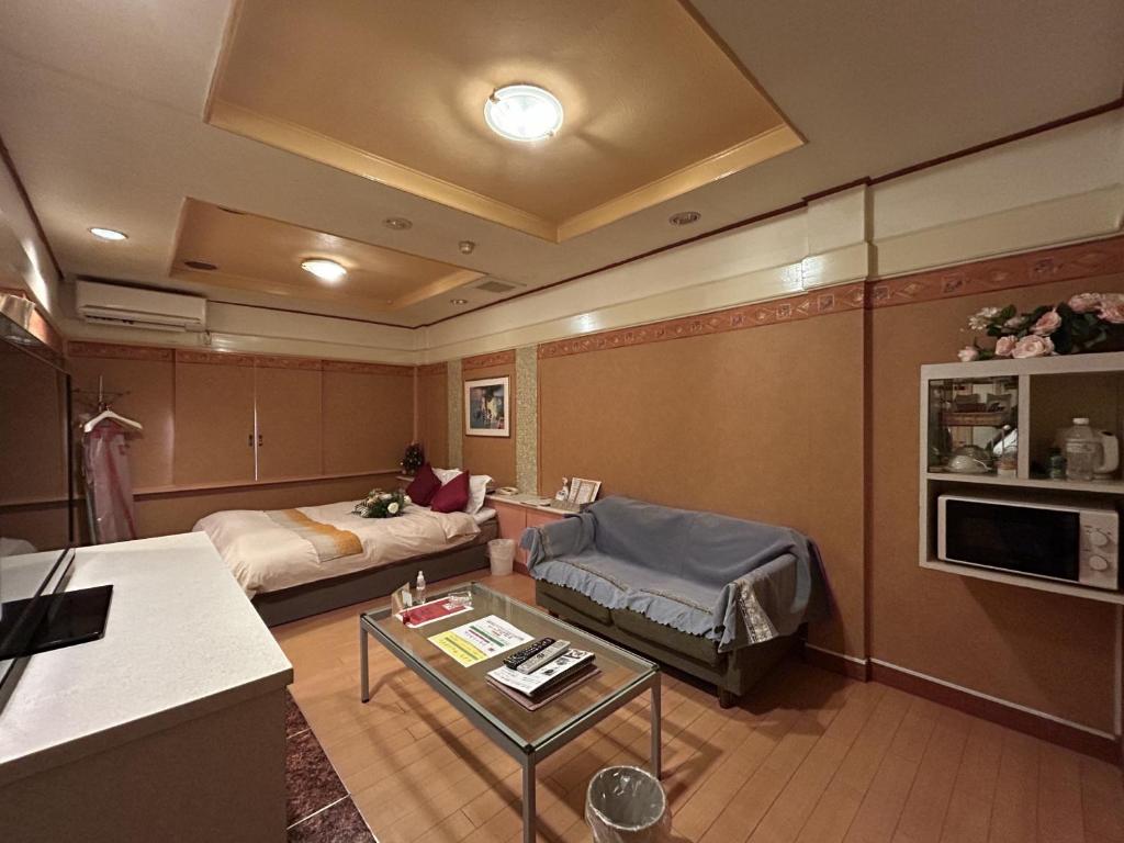 un salon avec un canapé et une table dans l'établissement ホテル オアシス, à Fukaya