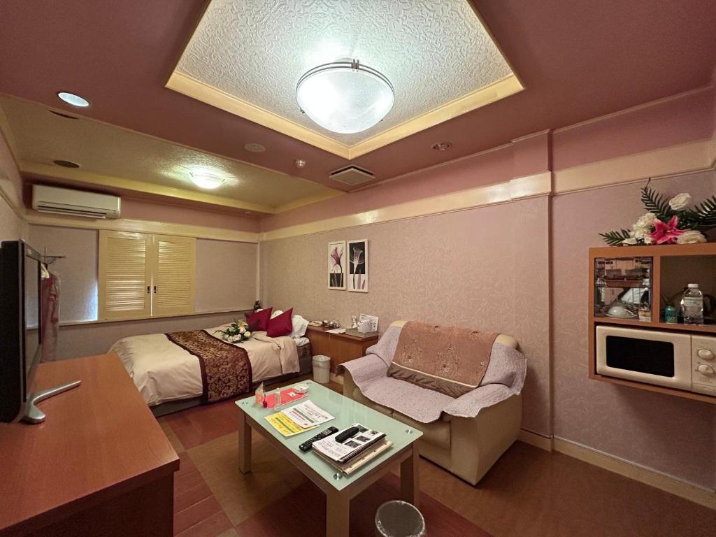 une chambre d'hôtel avec un lit et une table dans l'établissement ホテル オアシス, à Fukaya