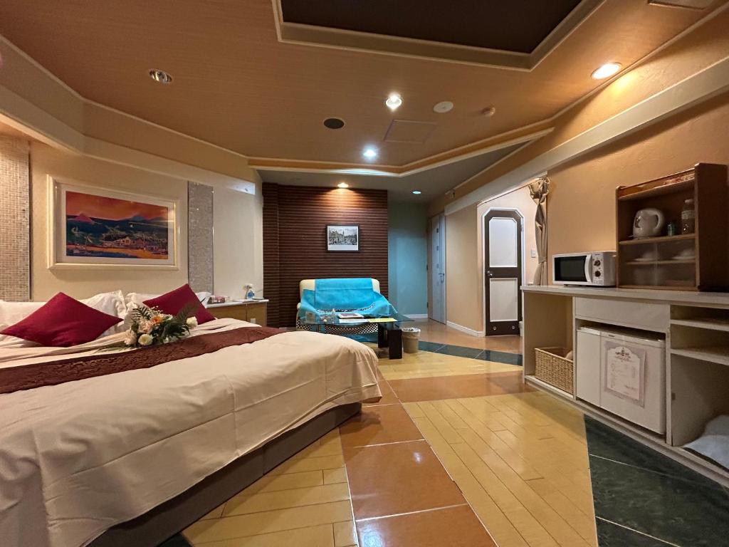 une chambre avec un grand lit dans une pièce dans l'établissement ホテル オアシス, à Fukaya
