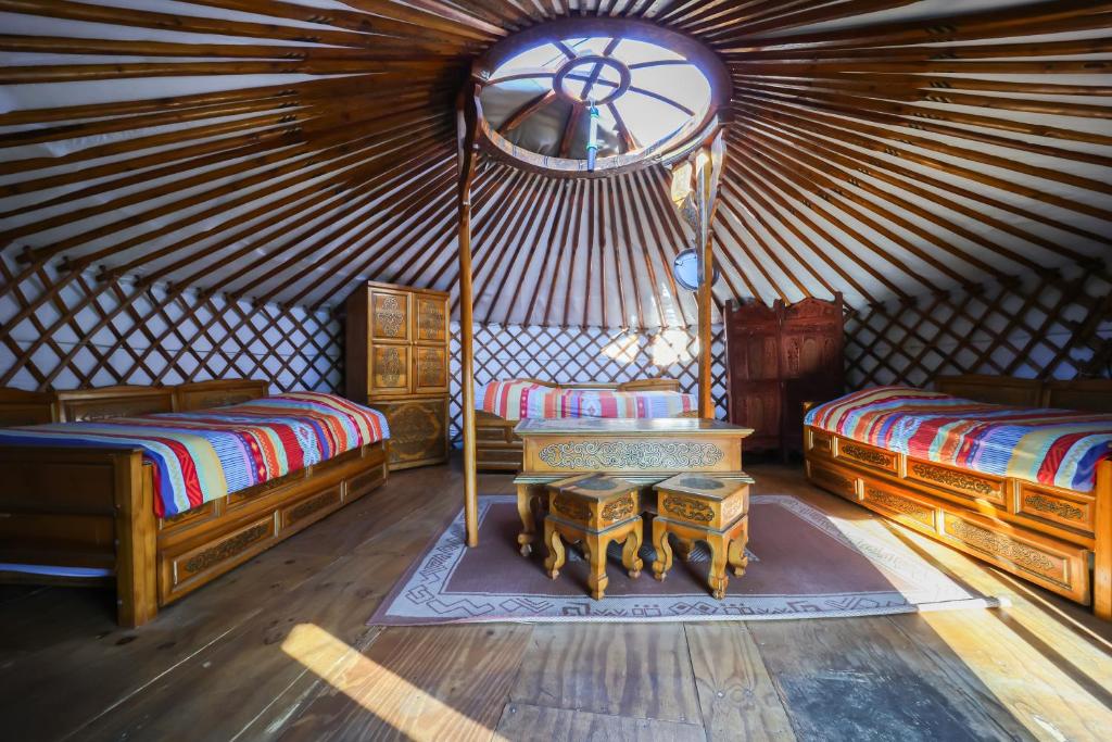 - une chambre avec 2 lits et une table dans une yourte dans l'établissement Yourtes Olachat proche Annecy, à Faverges 37 autres photos