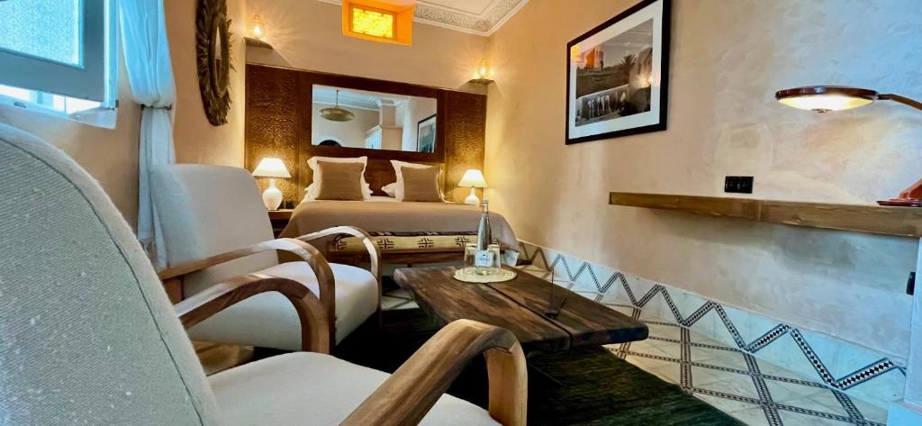 une chambre avec deux lits, une table et des chaises dans l'établissement Riad MALAÏKA, à Essaouira