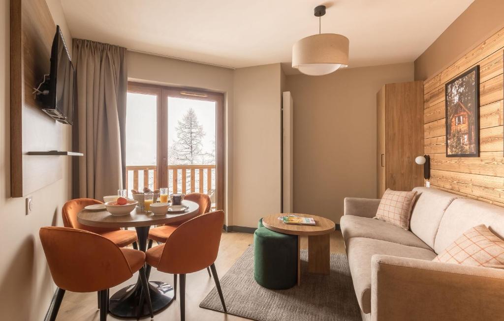un salon avec un canapé et une table dans l'établissement Résidence Odalys L'Ecrin de Vars, à Vars