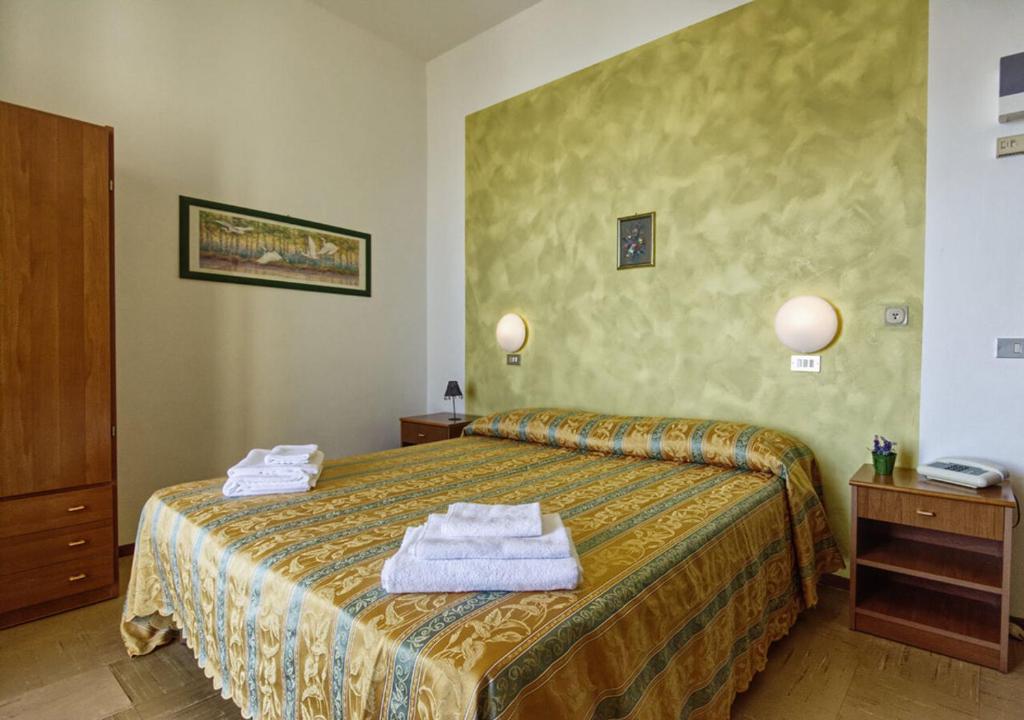 une chambre d'hôtel avec un lit avec des serviettes dessus dans l'établissement Hotel Pironi, à San Mauro a Mare
