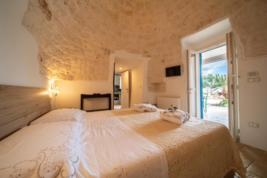 une chambre avec un grand lit avec une grande fenêtre dans l'établissement IL Trullo Di Mamma Lucia-Luxury Villa, à Ostuni 59 autres photos