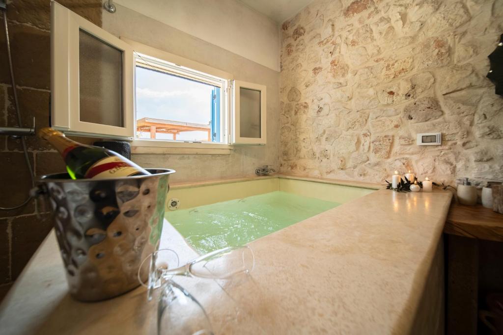 une baignoire avec un seau d'eau sur un comptoir dans l'établissement IL Trullo Di Mamma Lucia-Luxury Villa, à Ostuni