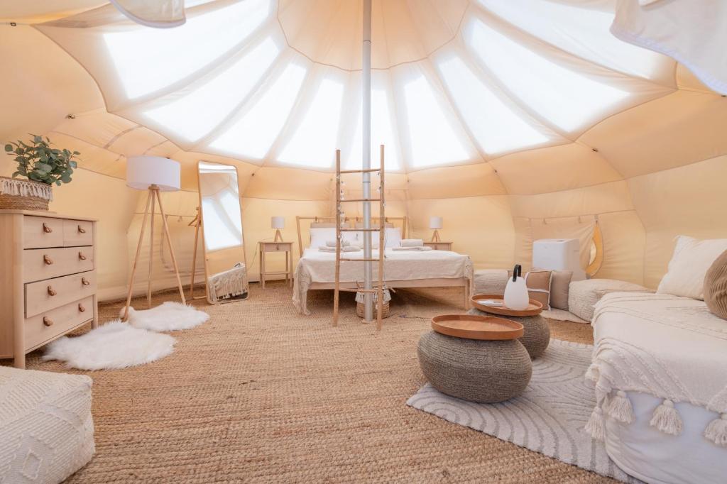 Cette chambre comprend une tente avec un canapé et une table. dans l'établissement VILLA OSTUNI ONE mit Pool, Gästehaus & Glamping, à Ostuni