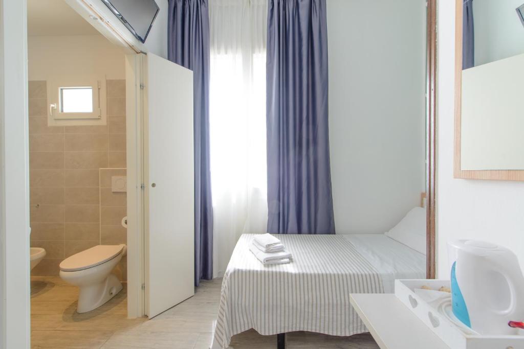 une salle de bain avec un lit, des toilettes et un lavabo dans l'établissement Nautic Beach Hotel, à Rimini
