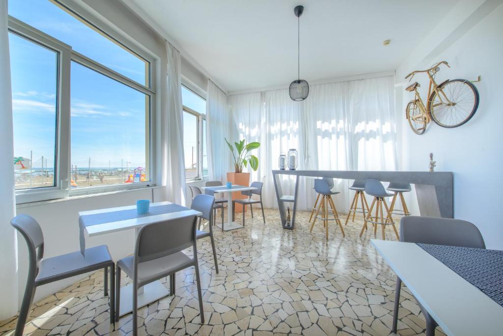 une salle à manger avec tables, chaises et fenêtres dans l'établissement Nautic Beach Hotel, à Rimini
