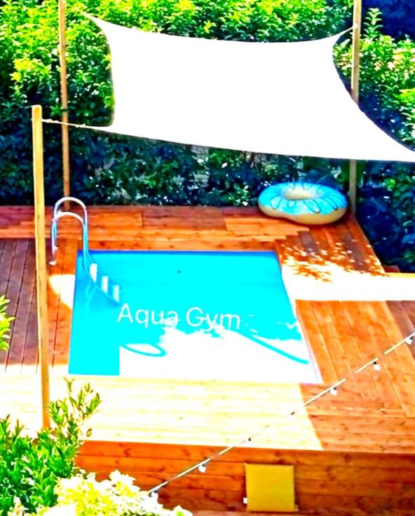 un panneau indiquant aquarius gym sur une terrasse en bois dans l'établissement Pompei Home & Green Luxury Apartment, à Boscoreale