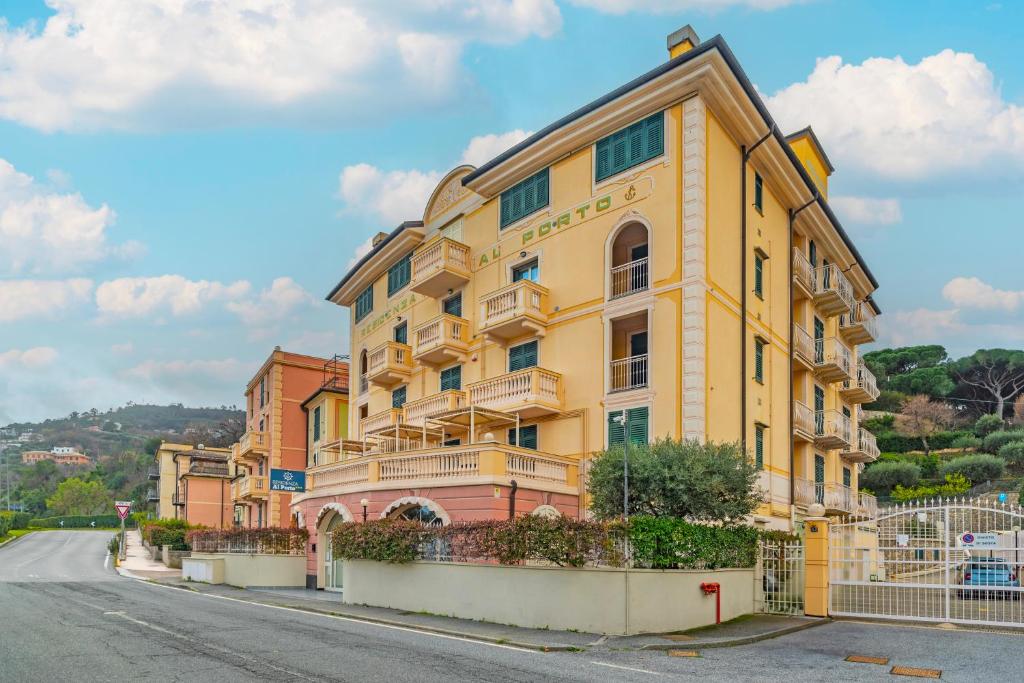 un bâtiment jaune au bord d'une rue dans l'établissement Residenza al Porto, à Spotorno