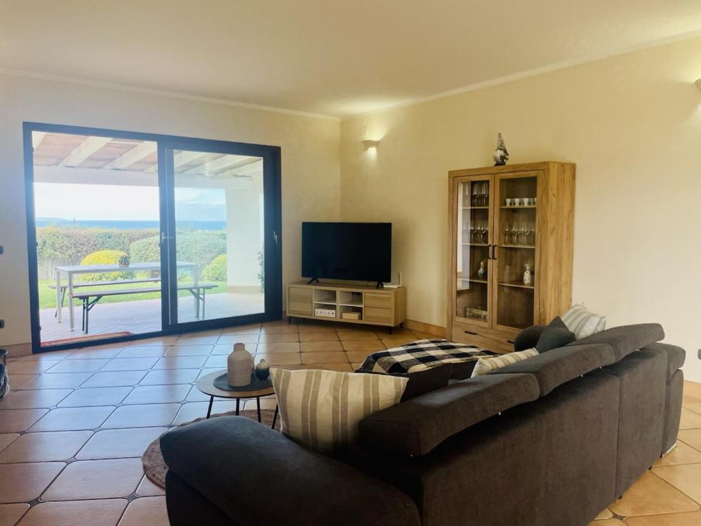un salon avec un canapé et une télévision à écran plat dans l'établissement Villa esclusiva con piscina privata e vista mare, à San Michele