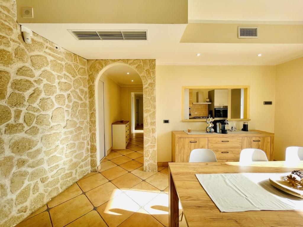une cuisine et une salle à manger avec un mur en pierre dans l'établissement Villa esclusiva con piscina privata e vista mare, à San Michele