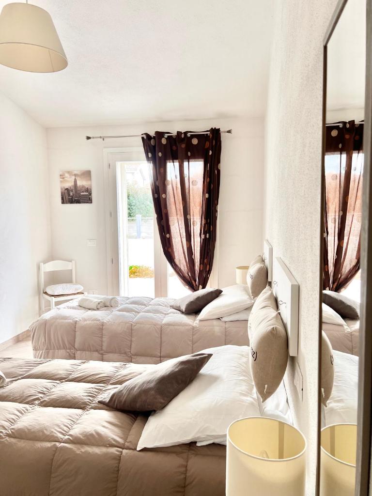 une chambre avec trois lits et une fenêtre dans l'établissement Villa Etienne - Key to Villas, à Valledoria