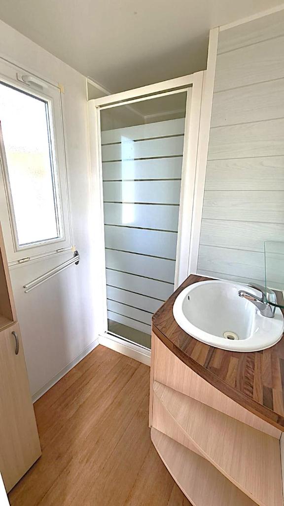 une salle de bain avec un lavabo et une fenêtre dans l'établissement MH acces Puy duFou 2 ch 5pers 210FS, à La Boissière-de-Montaigu