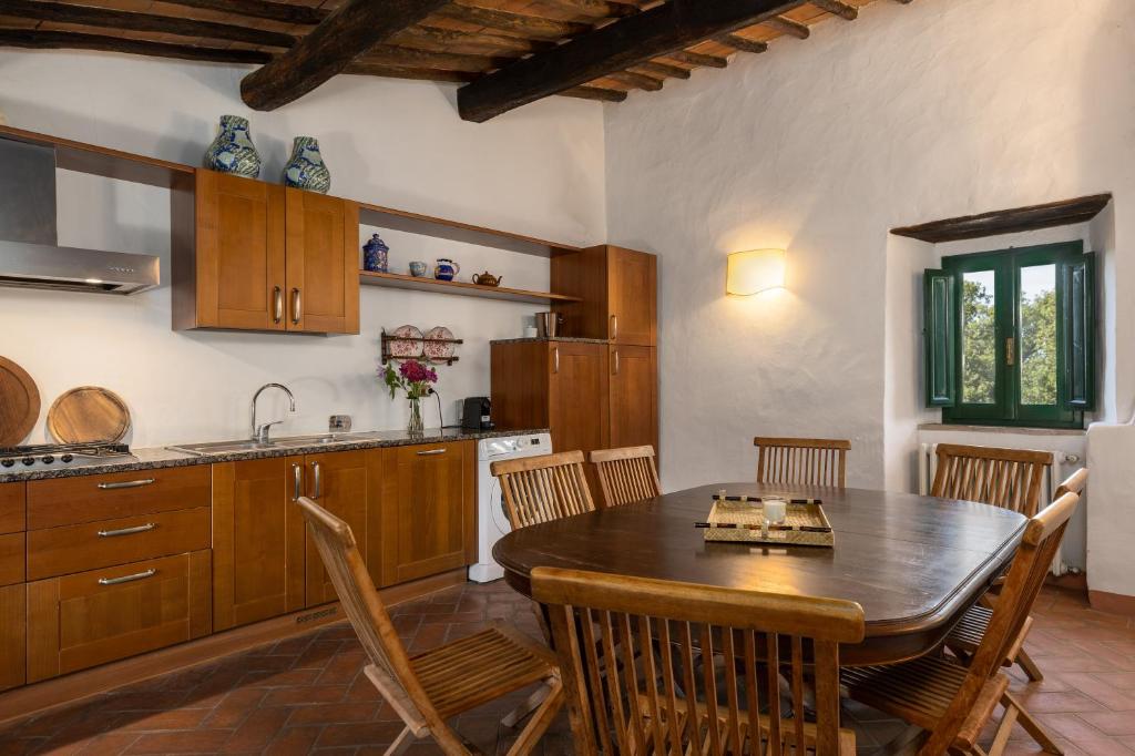 - une cuisine avec une table et des chaises en bois dans l'établissement Villa Rosano, à Greve in Chianti