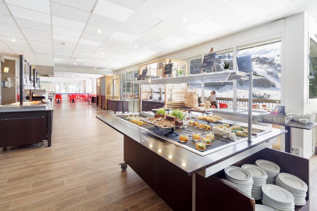 une cuisine avec un buffet de plats sur un comptoir dans l'établissement Belambra Clubs Gourette - Lou Sarri, à Gourette 36 autres photos