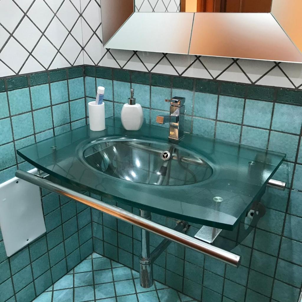 La salle de bains est pourvue d'un lavabo et d'un comptoir vert. dans l'établissement Pompei Home & Green Luxury Apartment, à Boscoreale 46 autres photos