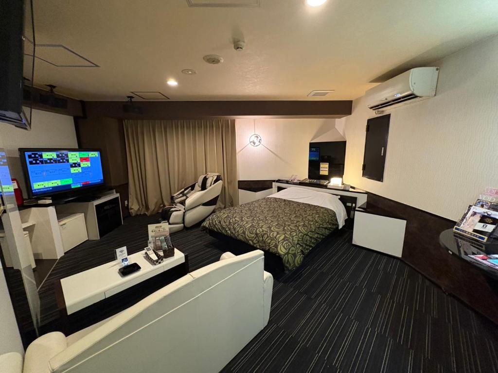 une chambre d'hôtel avec un lit et une télévision à écran plat dans l'établissement ホテル ウィズ男塾ホテルグループAdult Only, à Fukuyama